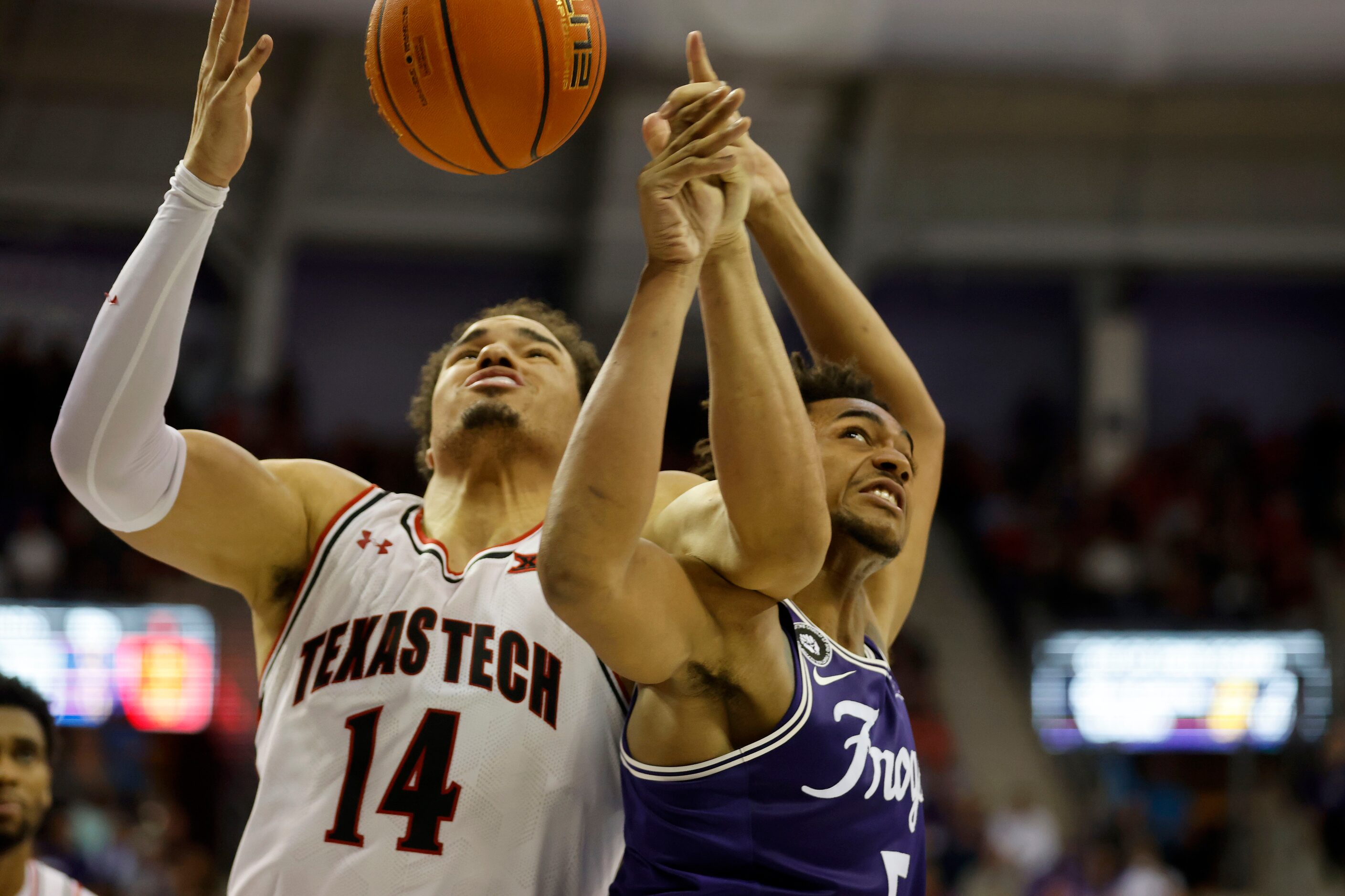 Texas Tech forward Marcus Santos-Silva (14) and TCU forward Chuck O'Bannon Jr. (5) battle...