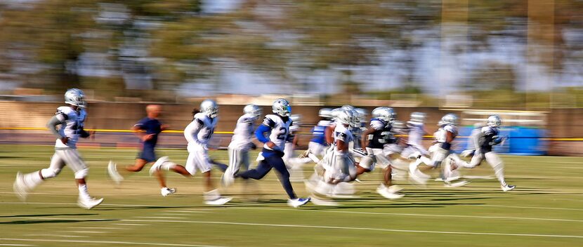 Dallas Cowboys players including running back Ezekiel Elliott (21) runs during the afternoon...