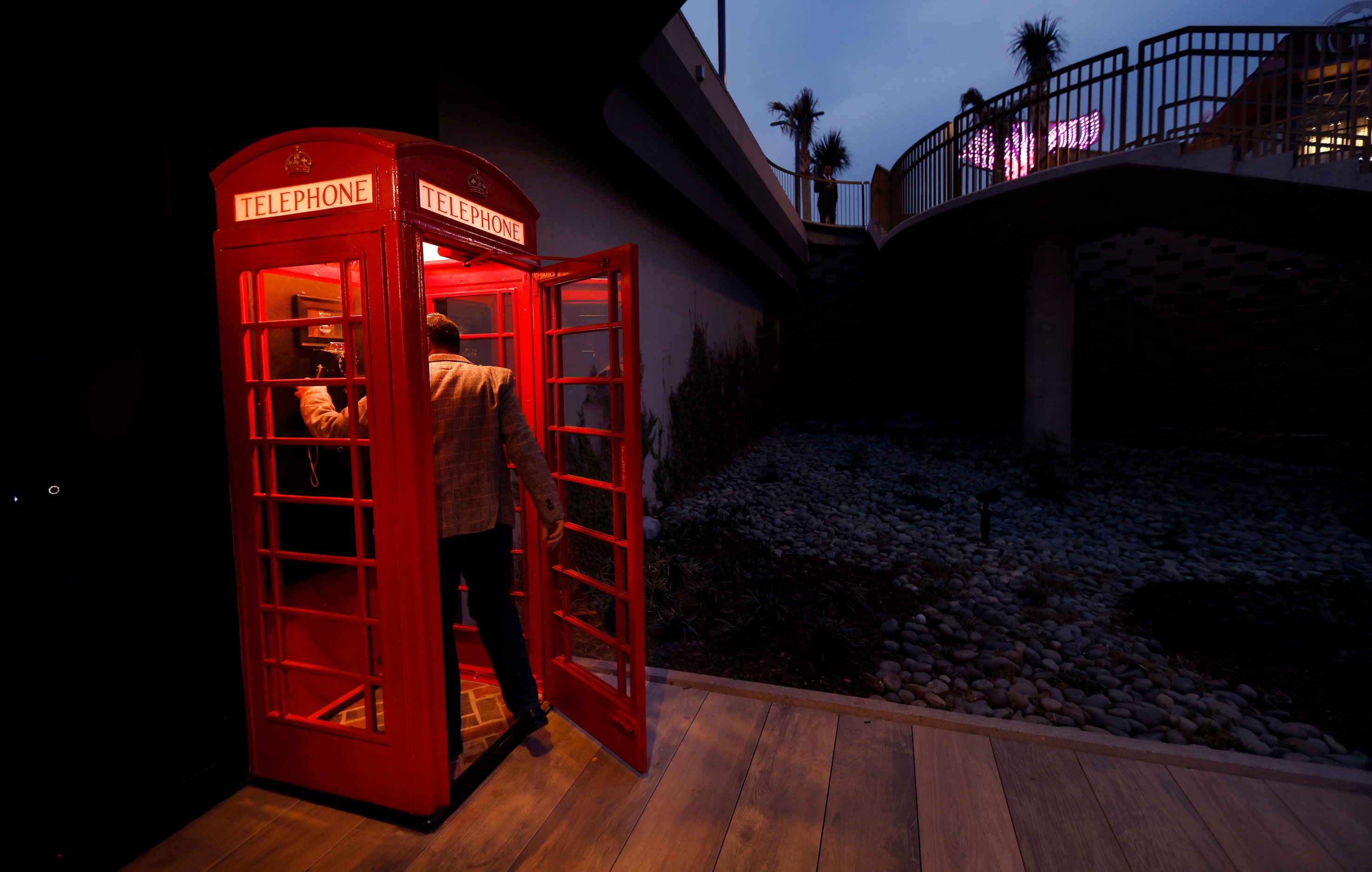 A guest makes entry through the london-syle phone booth during a press event at Red Phone...