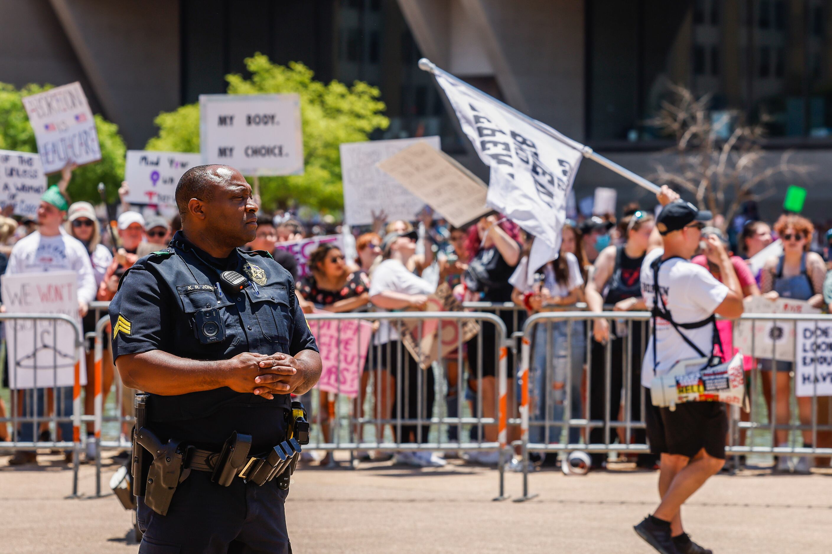 A Dallas Police officer guards as abortion rights supporters and opponents clash while...