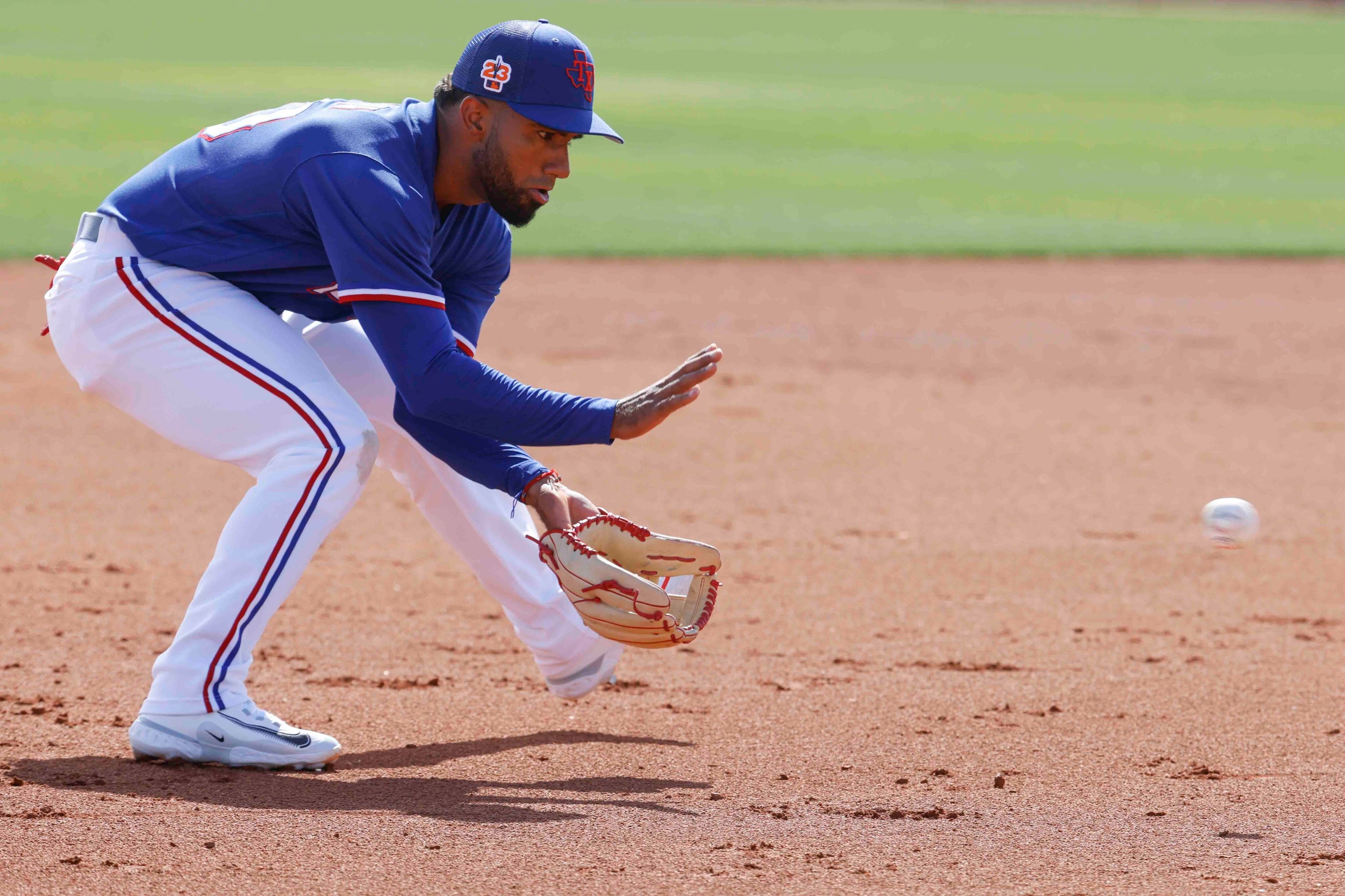 Texas Rangers infielder Ezequiel Durán fields during a ball during a spring training workout...