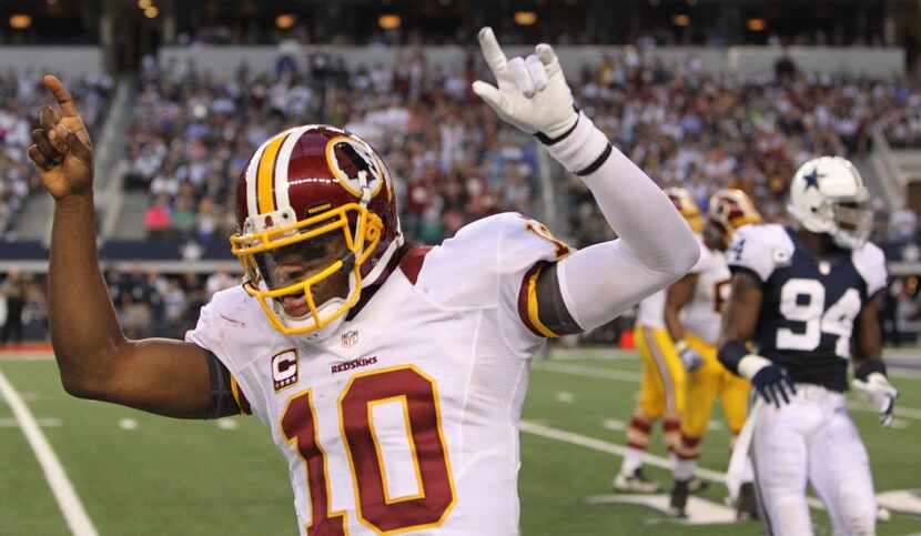 Washington quarterback Robert Griffin III celebrates his touchdown pass with just seconds...