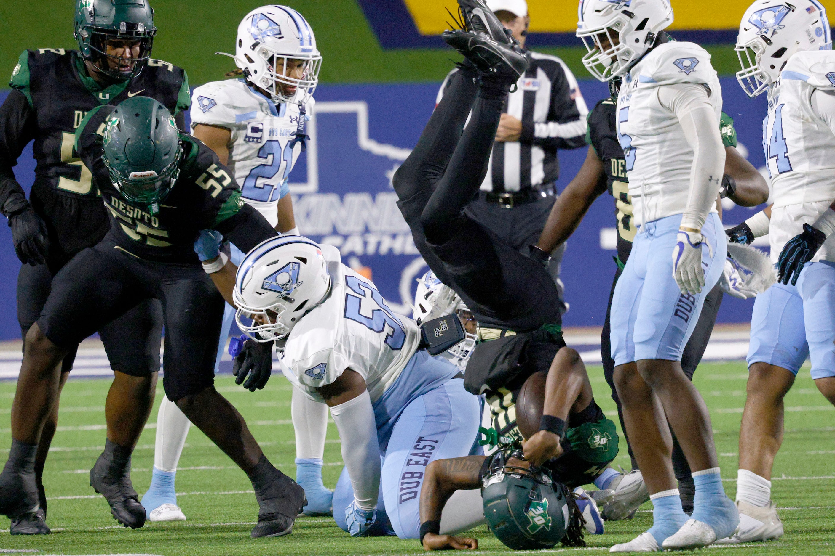 DeSoto's Legend Howell (14) is flipped upside down by Wylie East's Joshua Randleston (52) in...