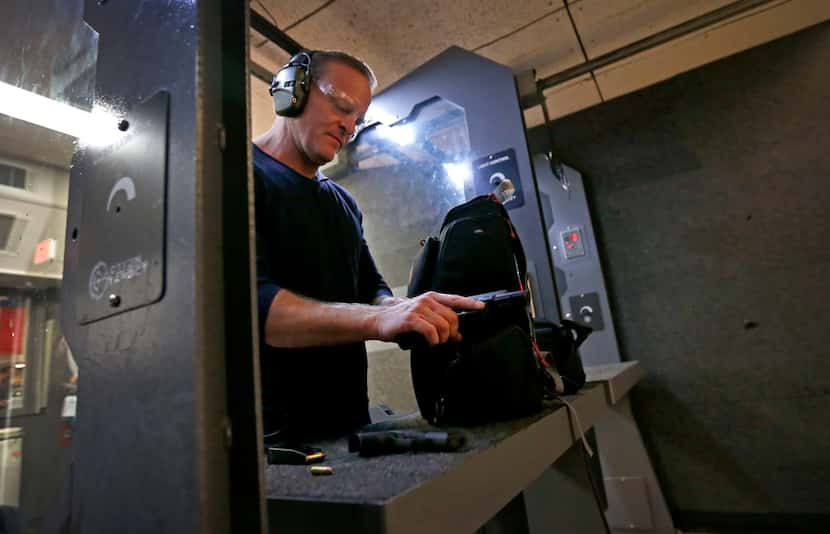 NRA TV anchor and reporter Grant Stinchfield checks his handgun after firing at DFW Gun...