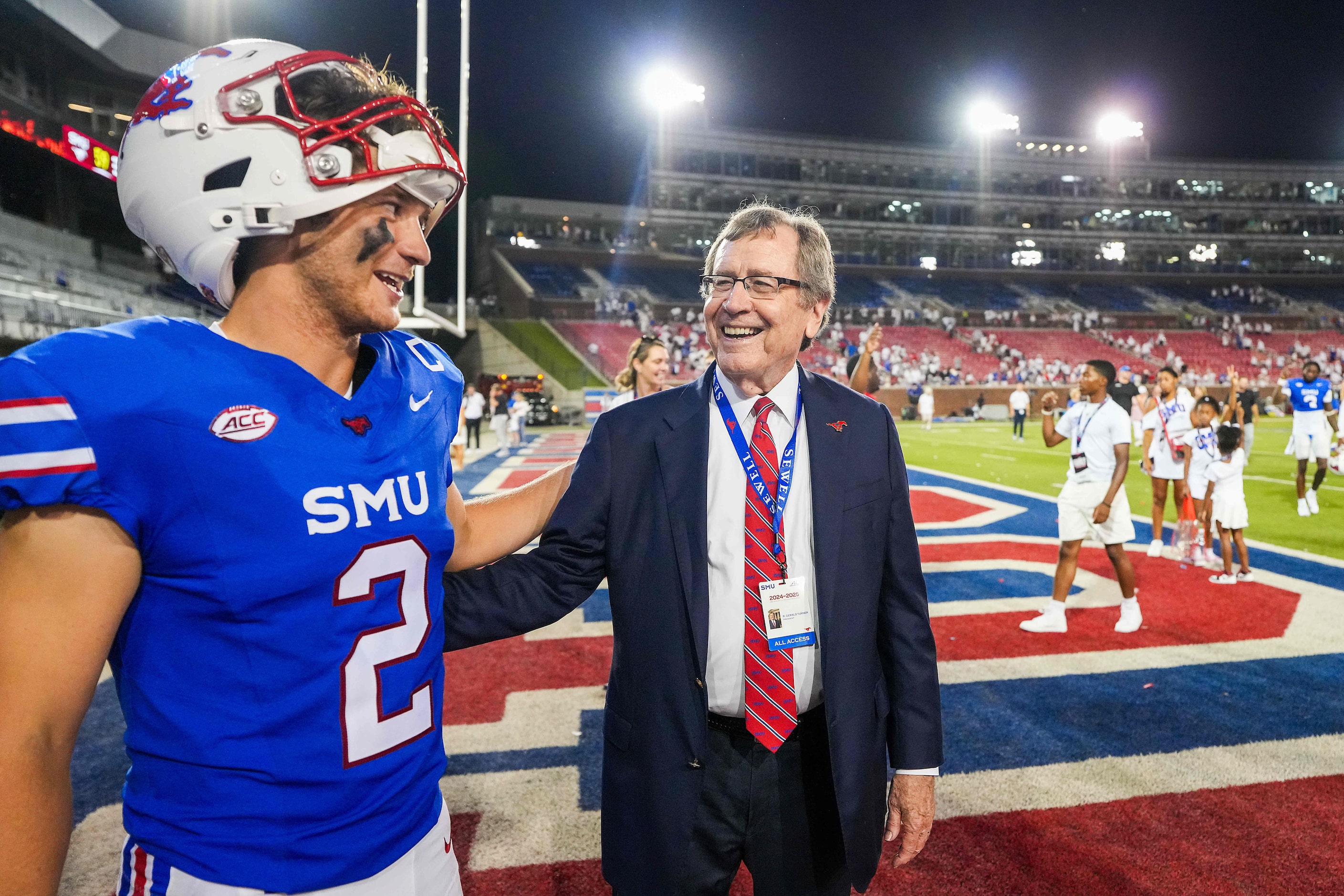 SMU president R. Gerald Turner laughs with quarterback Preston Stone (2) after a victory...