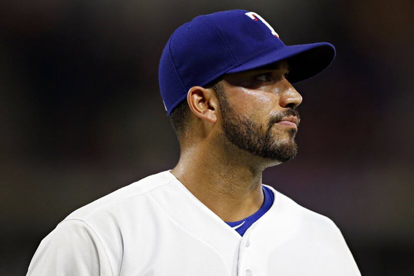 Texas Rangers relief pitcher Matt Bush walks back to the dugout dejected after surrendering...