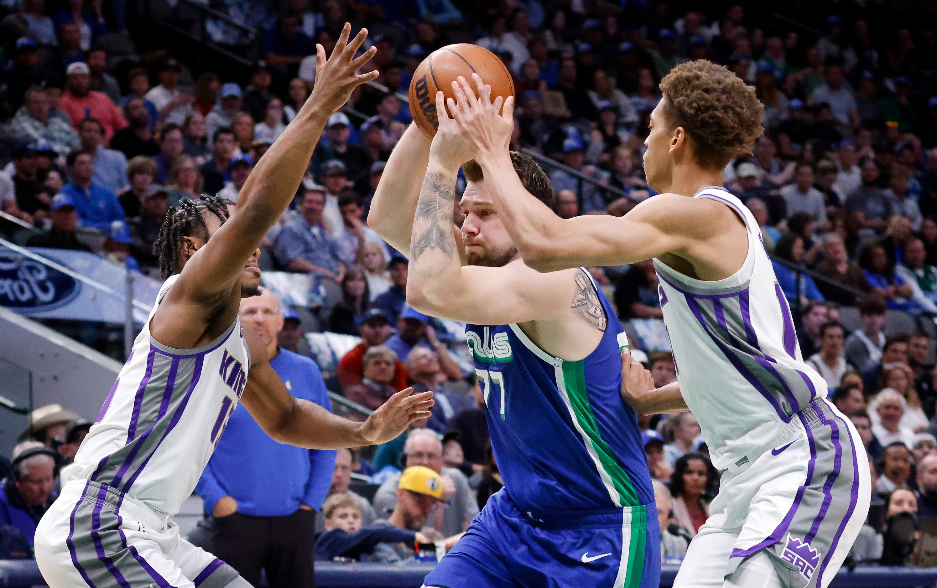 Dallas Mavericks guard Luka Doncic (77) drives between Sacramento Kings guard Davion...