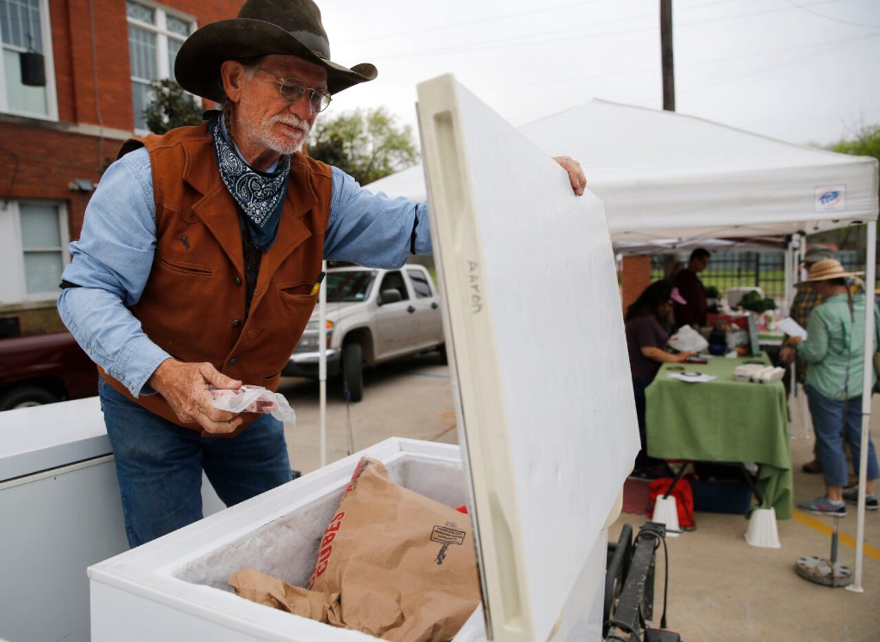 JuHa Ranch's Harry Butaud of Barry pulls lamb loin chops for a customer during opening day...