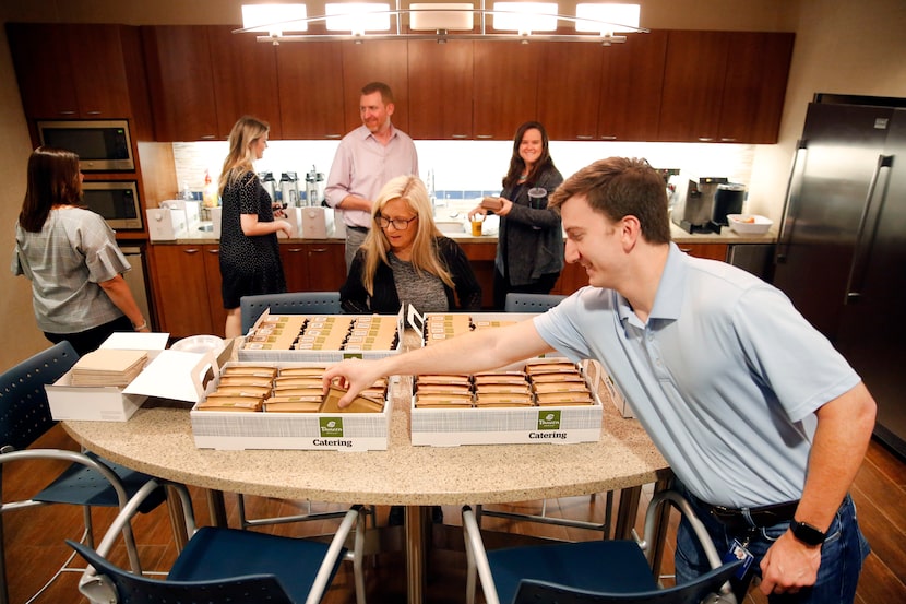 James Farrell, a senior benefits analyst, reaches for breakfast during an employee...