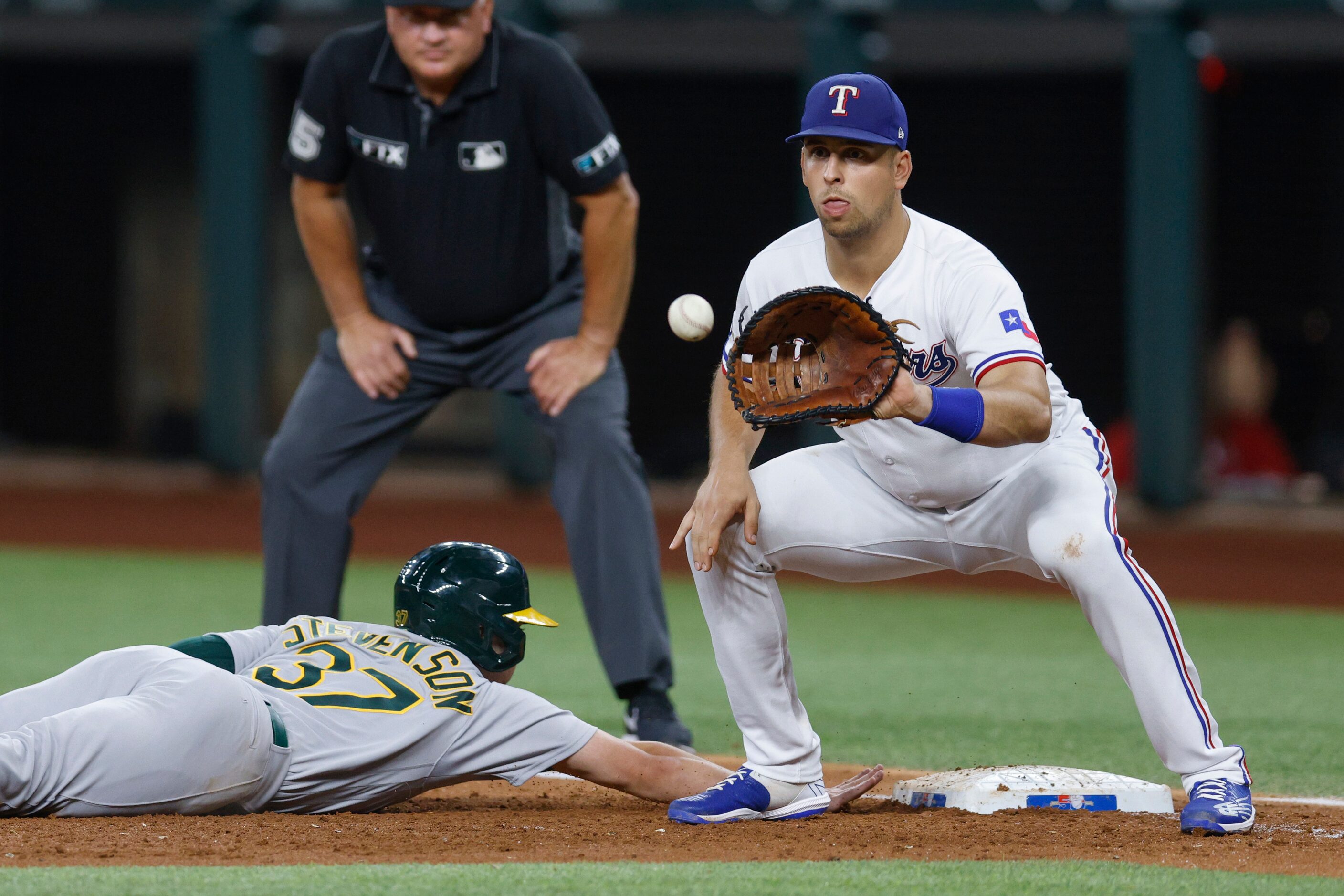 Texas Rangers first baseman Nathaniel Lowe (30) fields the ball as Oakland Athletics center...