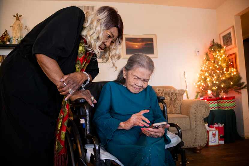 Lucila Oblena checks messages on her iPhone as Dorothy Jones looks on. They spent Wednesday,...