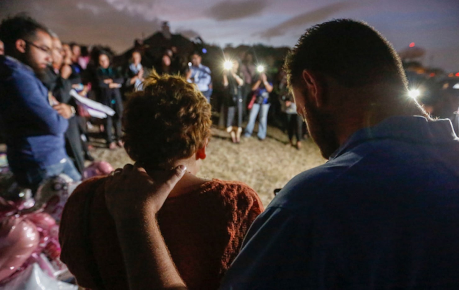 Nicole and Scott Snyder bow their heads in prayer at a vigil for Sherin Mathews in...