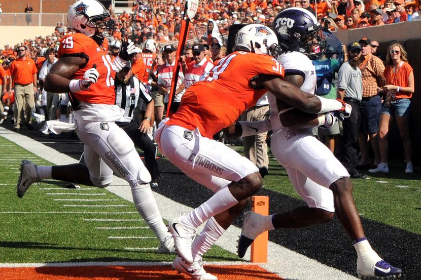 TCU running back Darius Anderson (6) scores a touchdown under pressure from Oklahoma St...