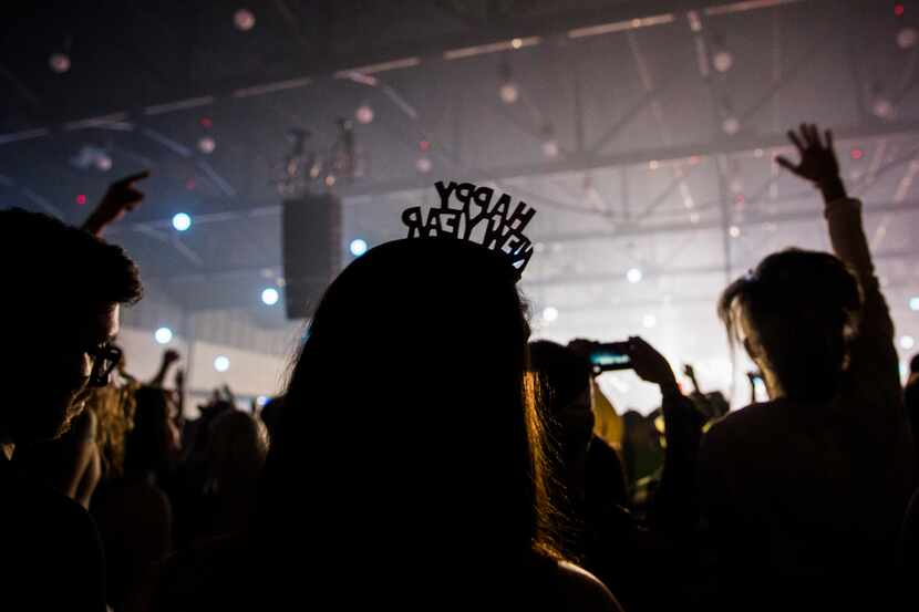 A woman wears a Happy New Year tiara during the Lights All Night New Year's Eve party on...