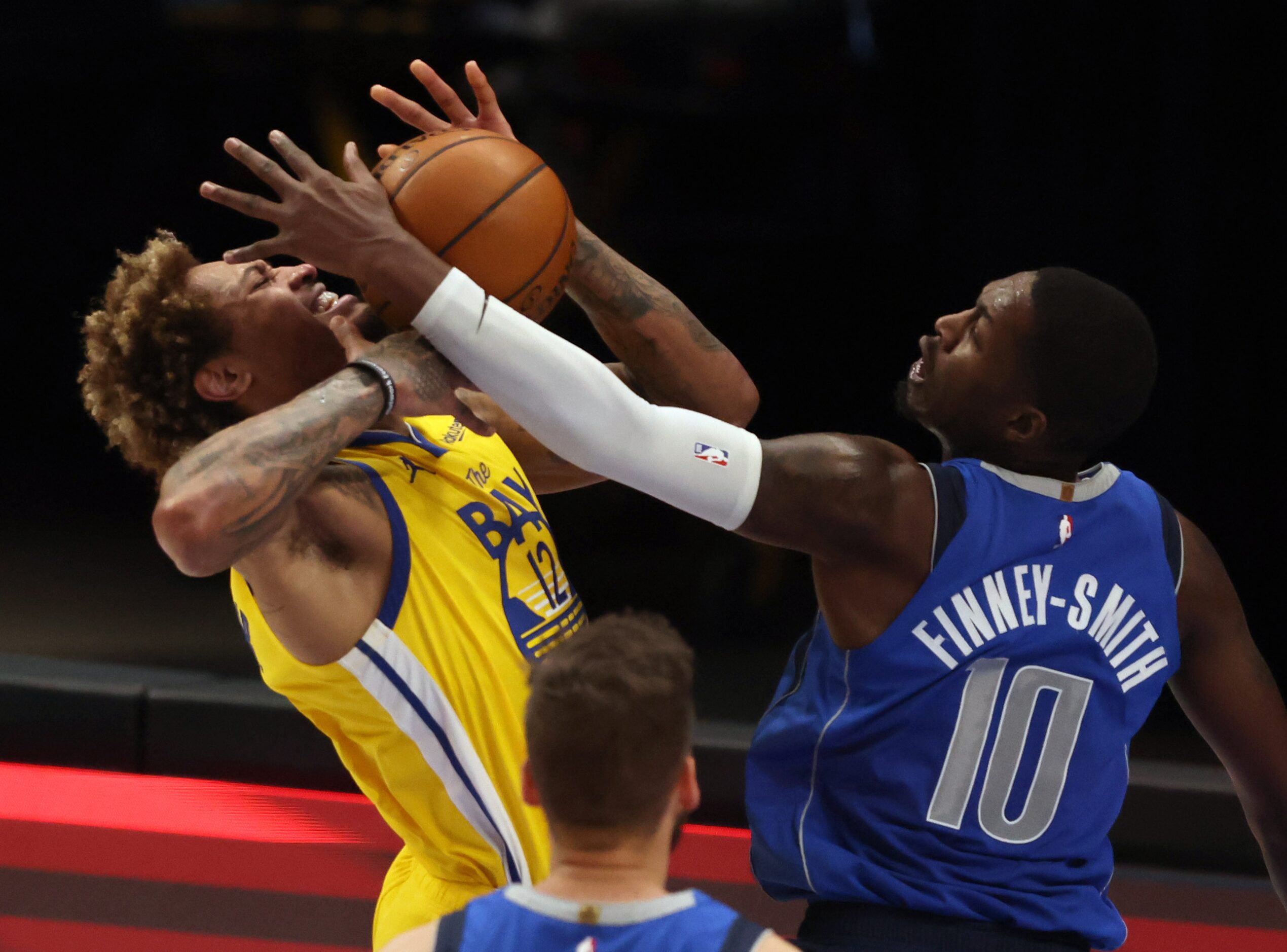 Dallas Mavericks forward Dorian Finney-Smith (10) fouls Golden State Warriors guard Kelly...