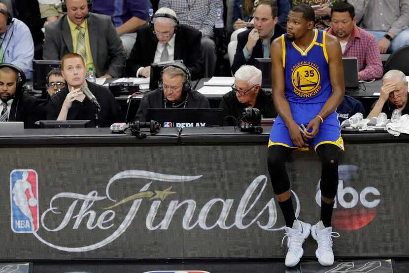 Golden State Warriors' Kevin Durant (35) sits on the officials table waiting to go in during...