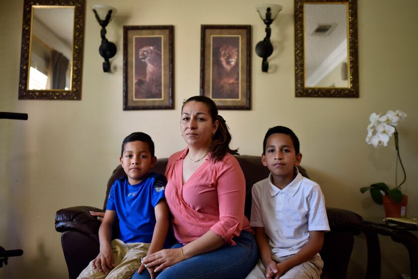 Marta Hernandez sits with her sons Kenneth, 8, and Cesar, 11, in the family's Irving home....