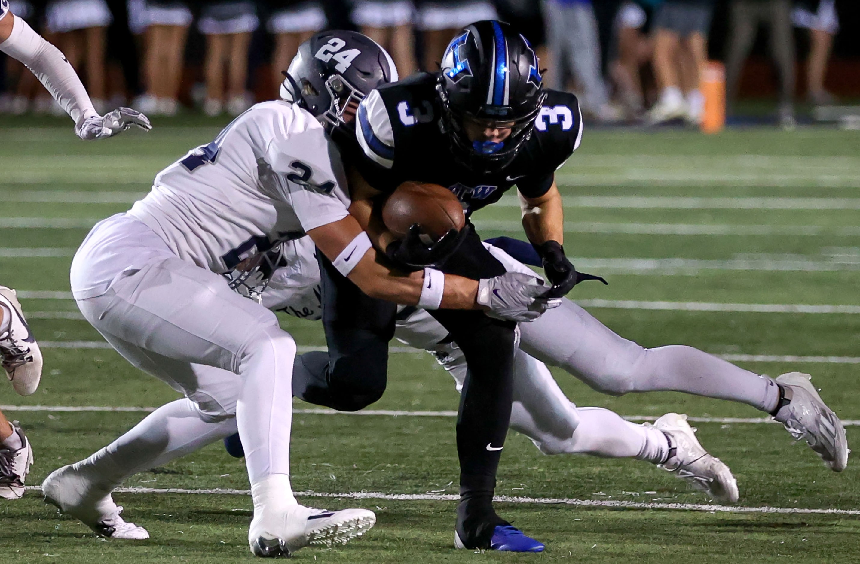 Hebron wide receiver Drew Koster (3) tries to break free from Flower Mound safety Slate...