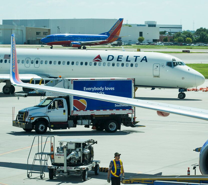  A Delta Air Lines jet taxis between two Southwest Airlines jets at Dallas Love Field....