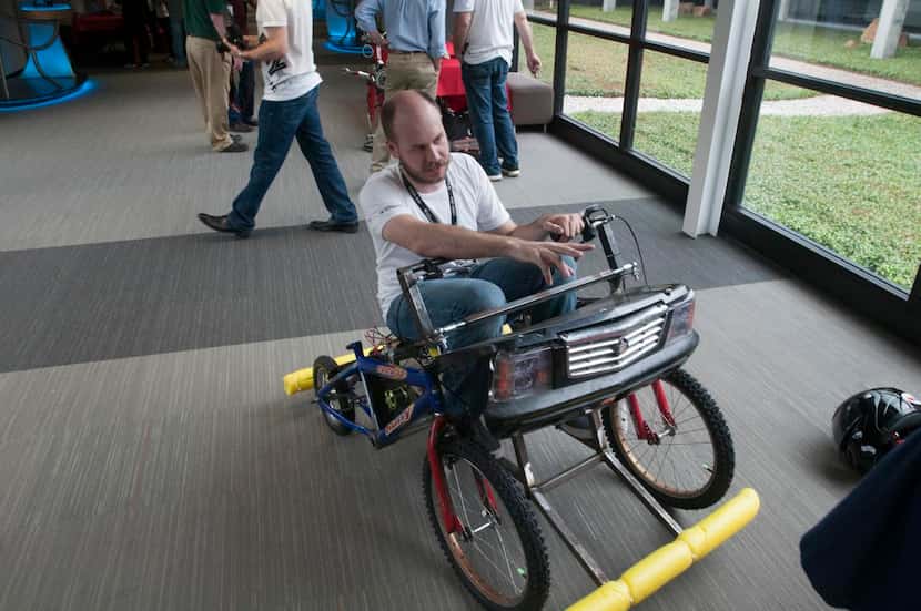 
Texas Instruments employee Trey German sits on his electric car paritally made with TI...