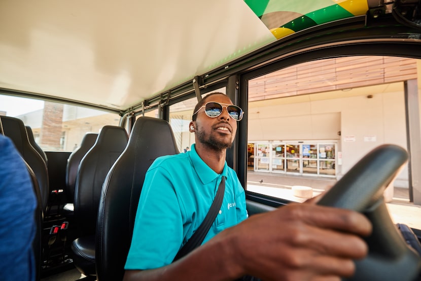 Circuit driver Jakwan Riddick, pictured in a turquoise polo shirt behind the steering wheel...