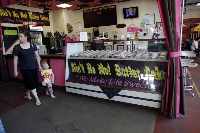 Patrons walk by the Ain't No More Butter Cake stand at the city of Dallas Farmers Market on...