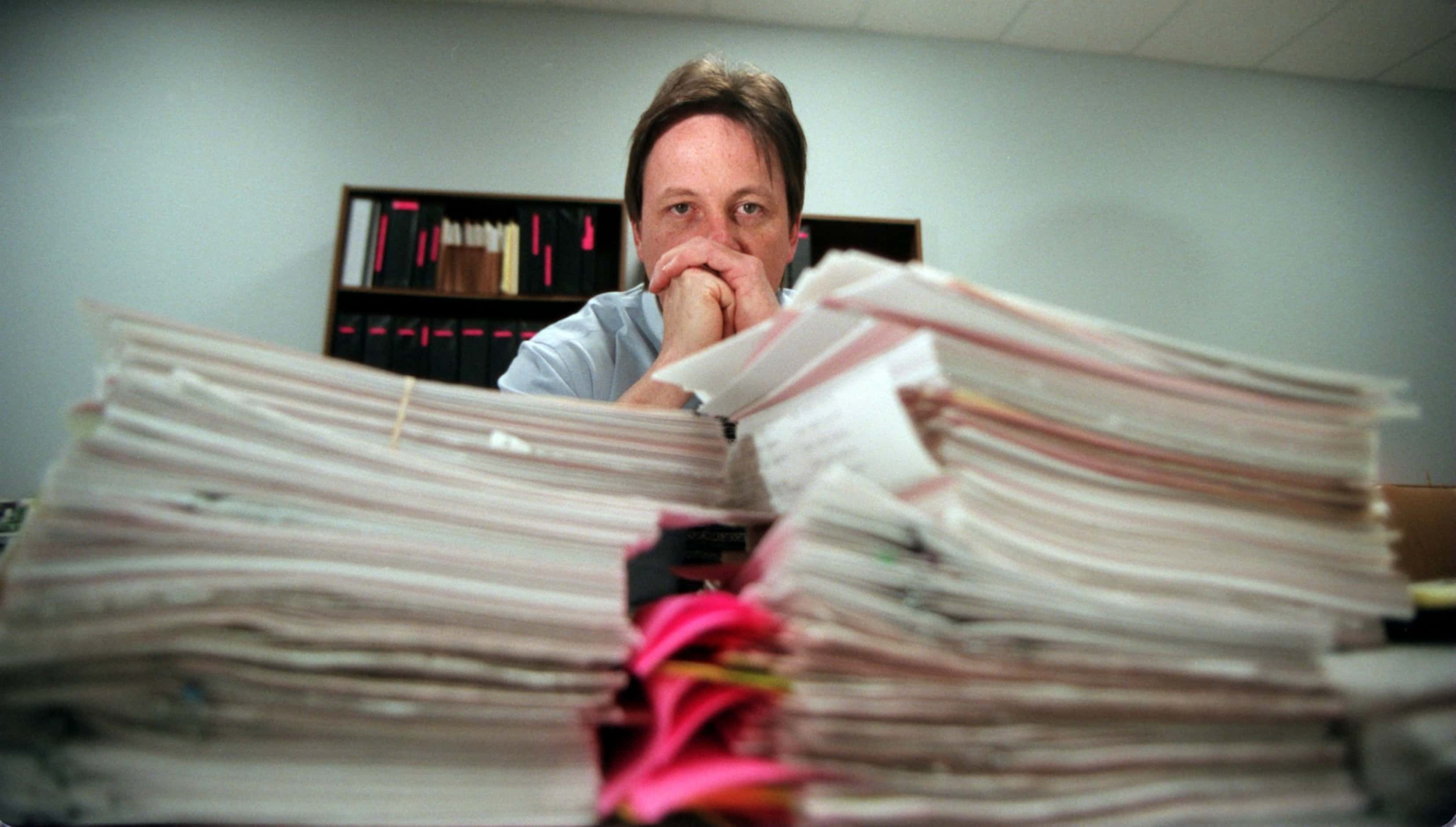 Sgt. Mark Simpson who is head of the Amber Hagerman Task Force sits behind stacks of paper...