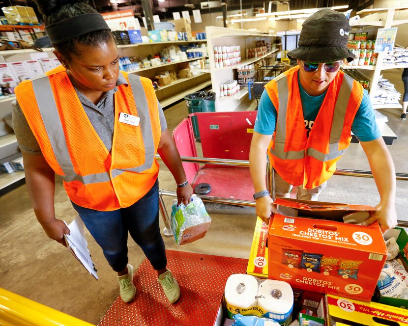 Raven Carr (left) and Eric Gallarza weigh food donations at Sharing Life Community Outreach...