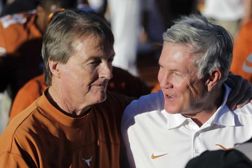 Texas coach Mack Brown, right, walks off the field with university president Bill Powers,...
