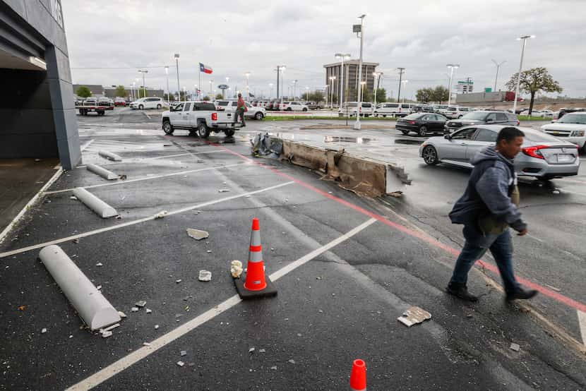 Damage from Autos of Dallas is dragged away from the front of the building after the...