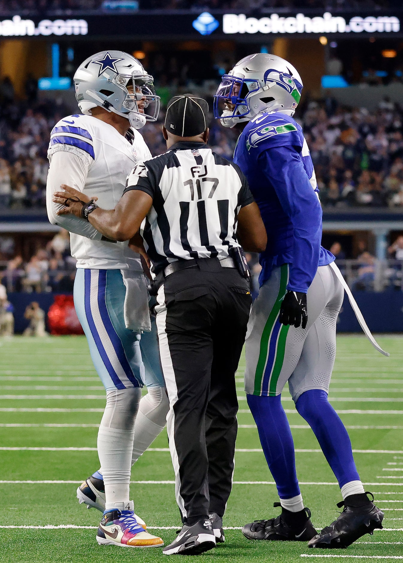 Field judge John Jenkins (117) separates Seattle Seahawks cornerback Riq Woolen (27) and...