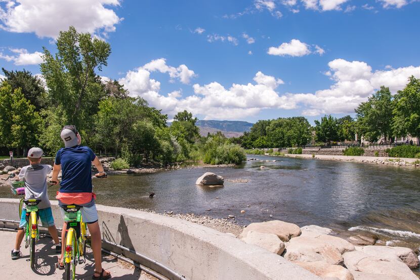 Two children on a bike trail stop to look at a lake in Lake Tahoe.