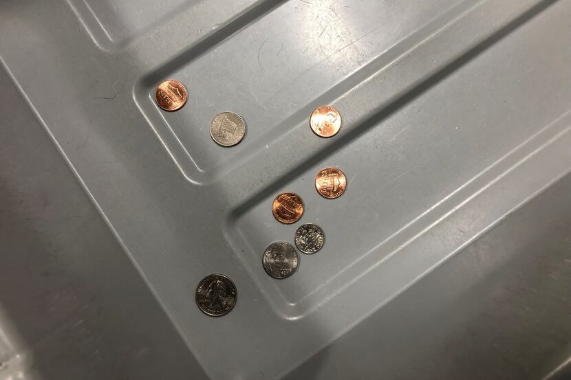 Loose change left behind in a Transporation Security Administration security checkpoint bin...