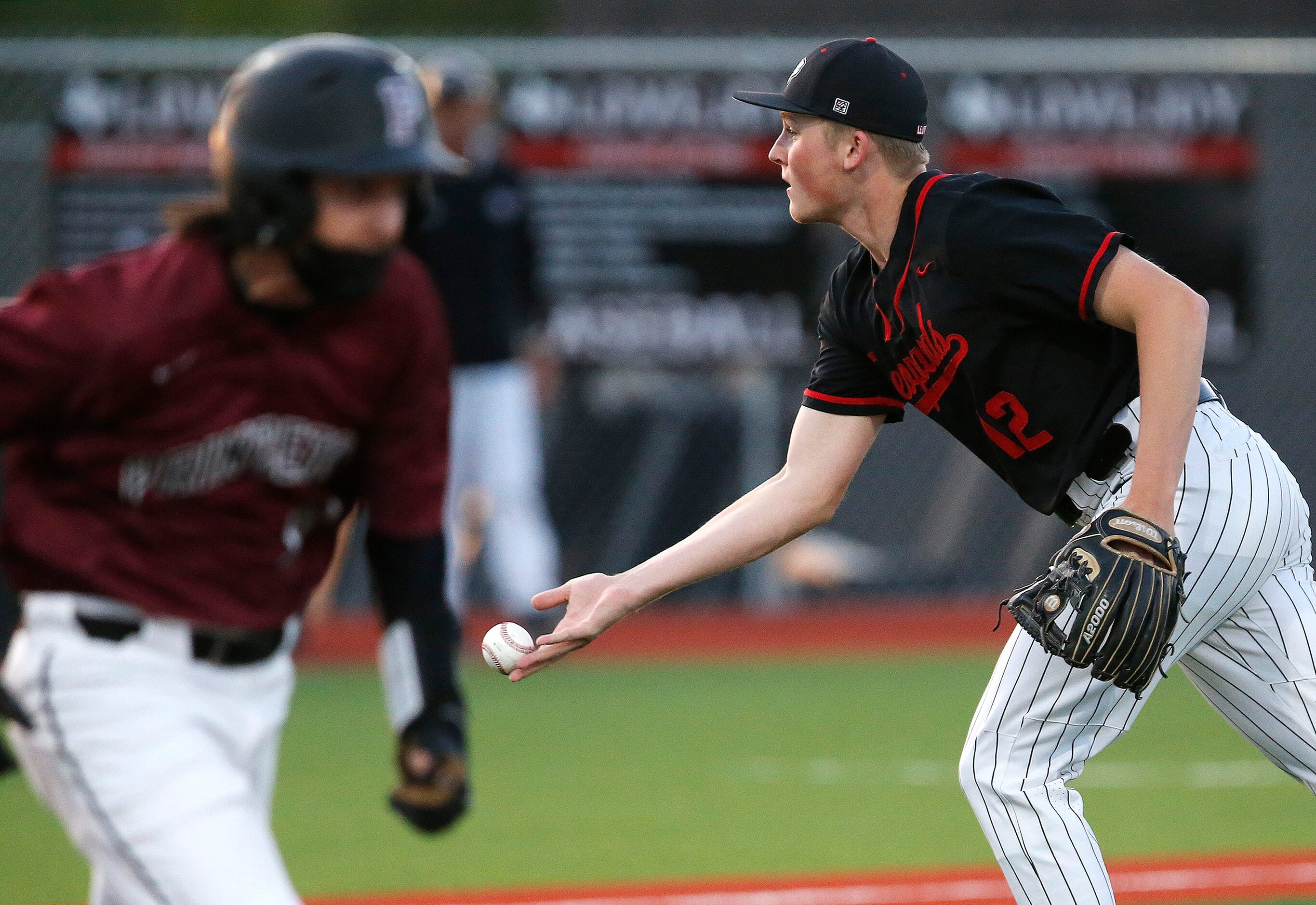 Lovejoy High School pitcher Parker Hutchins (12) makes a fielder’s choice and underhands the...