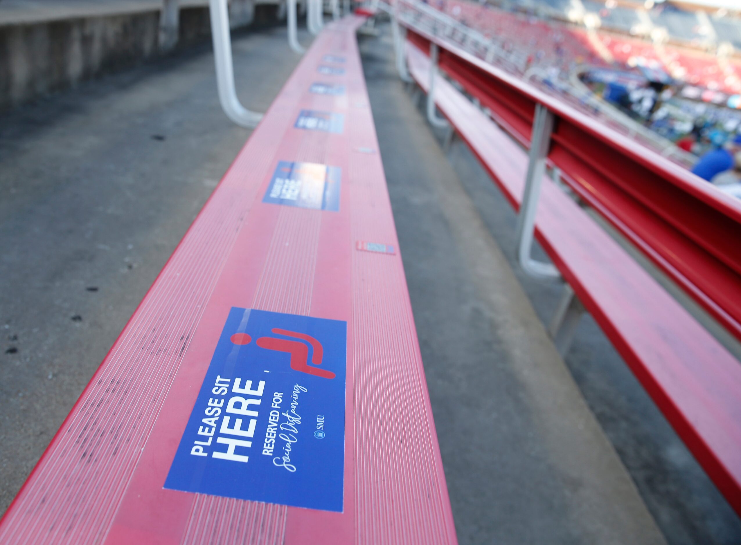 Stickers mark the spot where spectators can sit in a socially distanced area for a game...