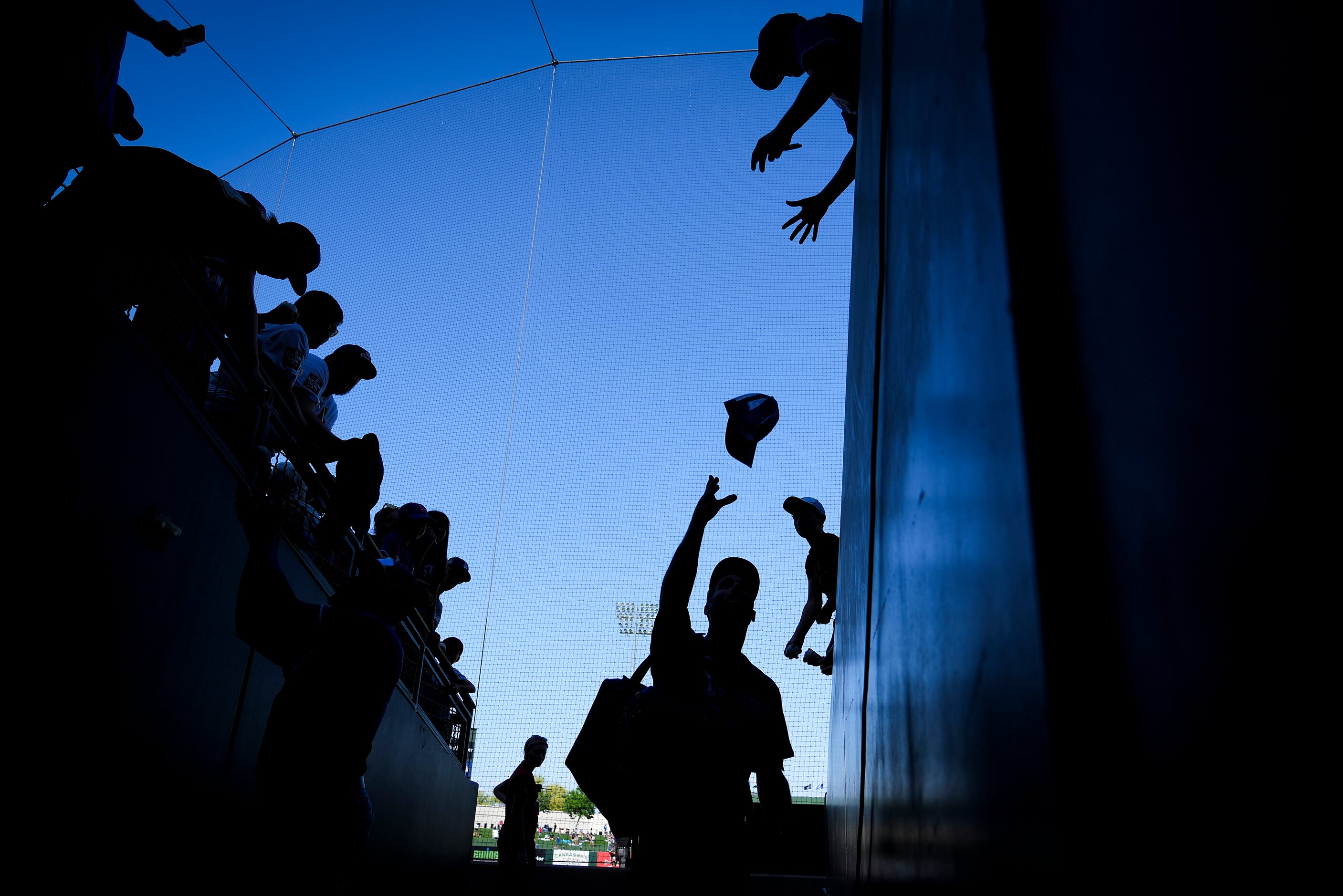 Los Angeles Dodgers center fielder Chris Taylor tosses a hat back to a fan while signing...