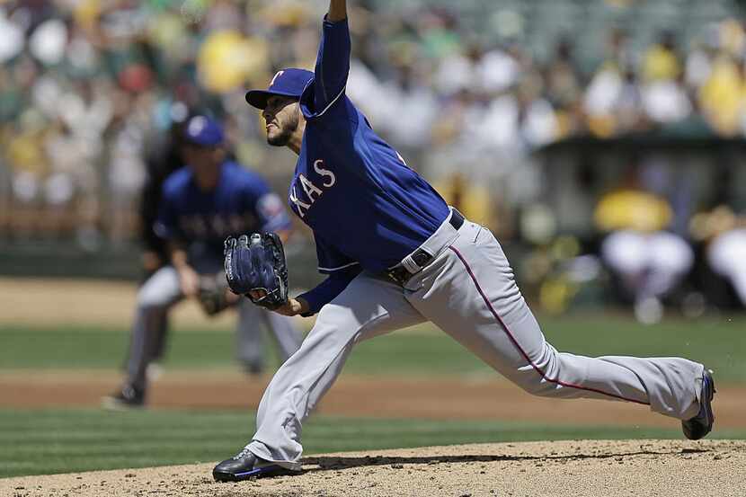 Texas Rangers' Martin Perez works against the Oakland Athletics in the first inning of a...