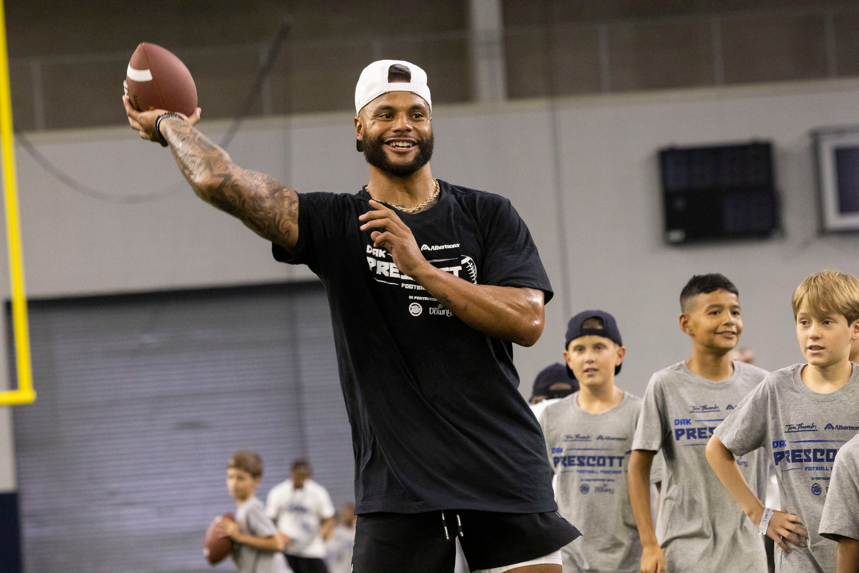 Cowboys quarterback Dak Prescott gets ready to throw the ball while running drills with...