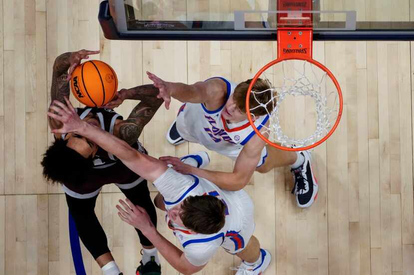 Texas A&M forward Andersson Garcia (11) is defended by Florida forward Thomas Haugh (10) and...