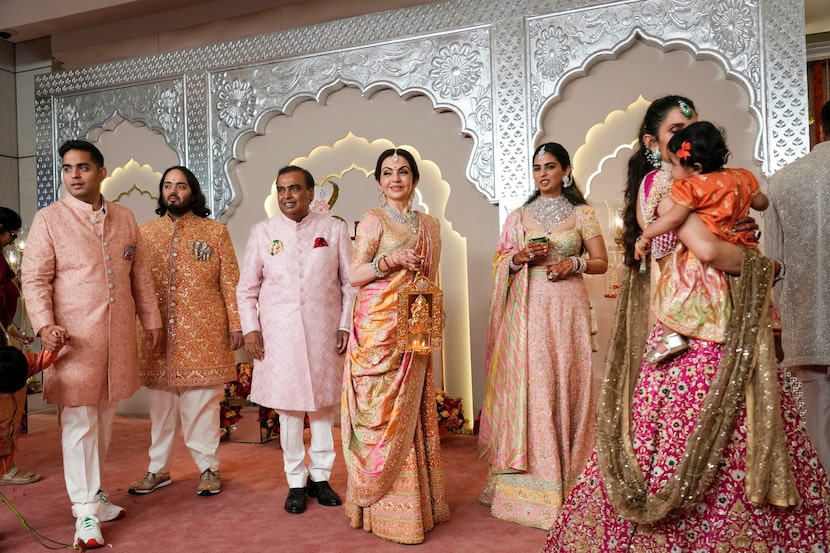 Billionaire Mukesh Ambani, third left, stands with his family members from left to right,...