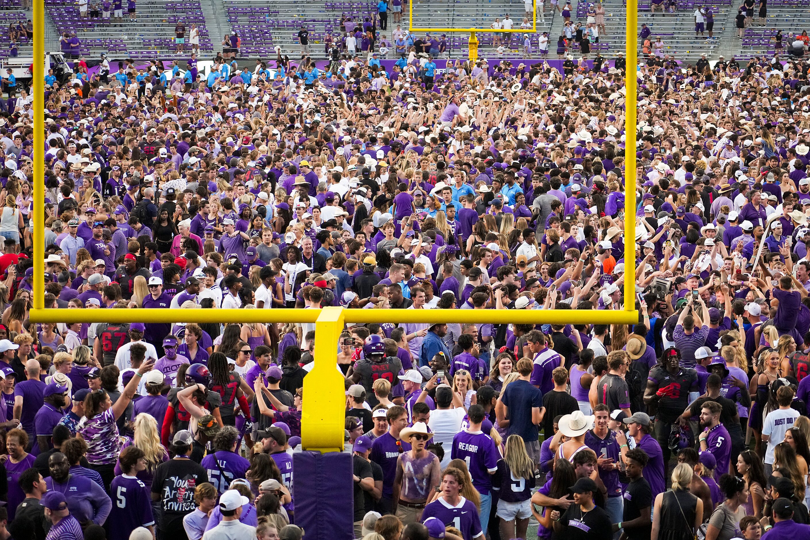 TCU fans storm the field after 43-40 double-overtime victory over Oklahoma State in an NCAA...