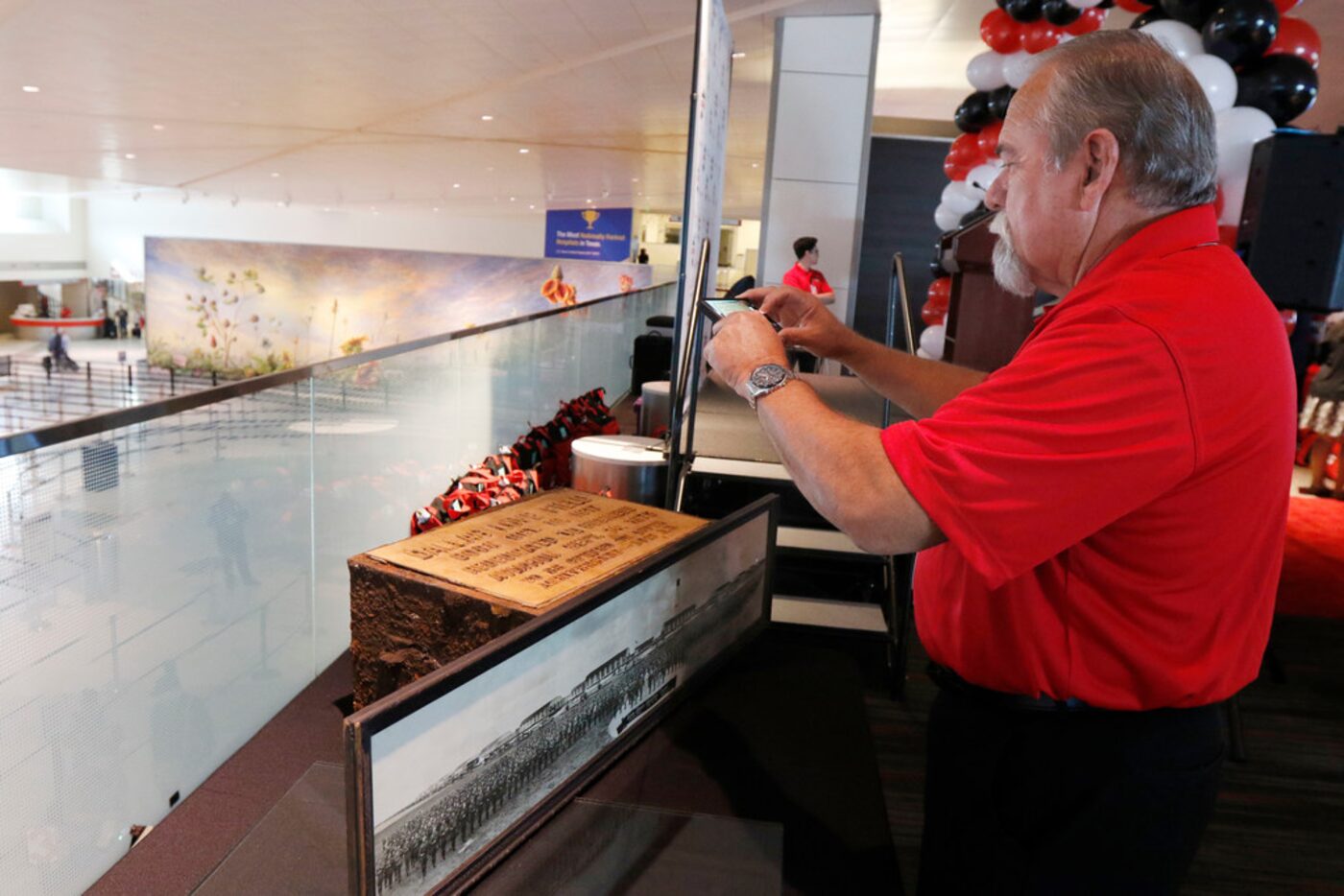 Timothy Smith of Dallas' aviation department takes a photograph of a time capsule on display...