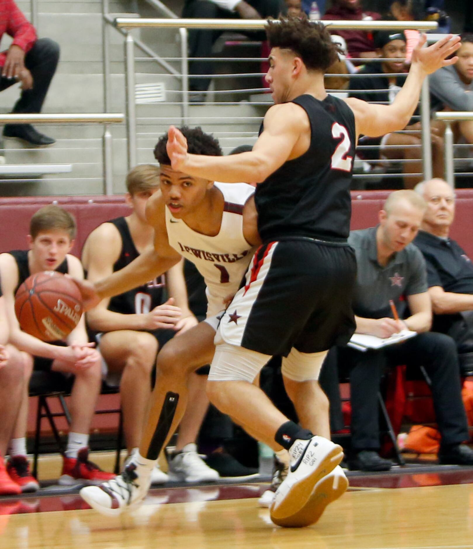 Lewisville's Keyonte George (1) goes low as he drives around the defense of Coppell's...