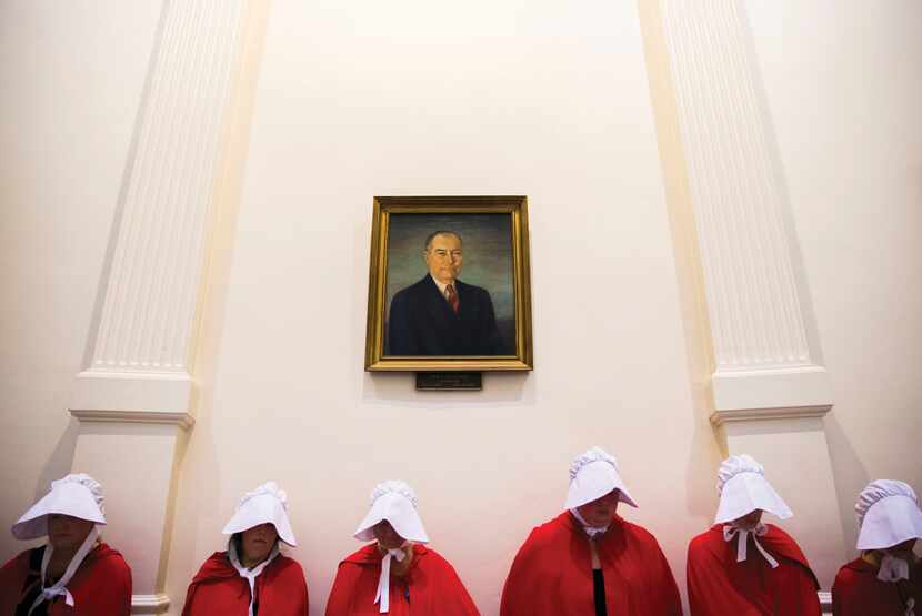 Dressed as the oppressed characters of "The Handmaid's Tale," supporters of women's health...