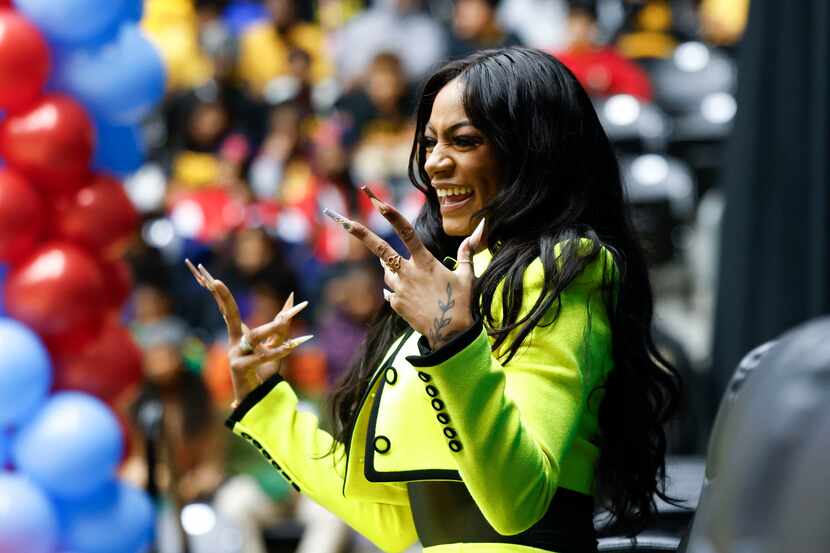 100 meters world champion Sha'Carri Richardson cheers towards the performing band during a...