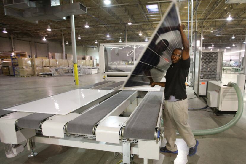 Johnny Morris moved a solar panel during production Thursday at 1 SolTech in Farmers Branch....