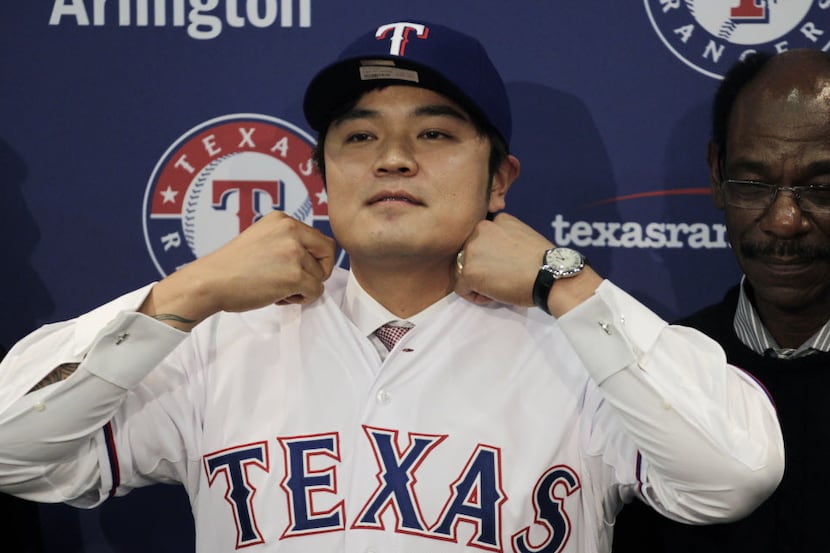 Shin-Soo Choo, of South Korea, adjusts the collar of his Texas Rangers jersey during a news...