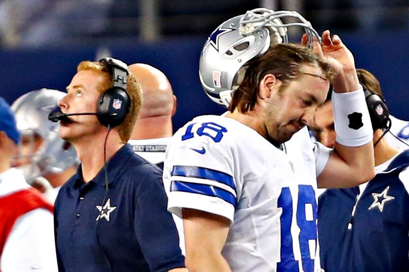 Dallas Cowboys quarterback Kyle Orton (18) walks past head coach Jason Garrett after...