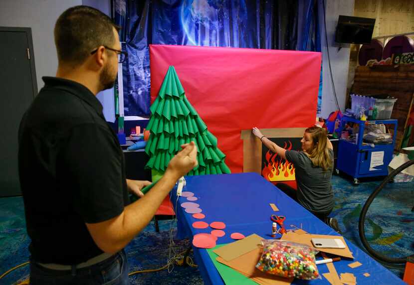 Jay Tom Ratliff and Arielle Lenox from Hilton corporate office help build a holiday photo...