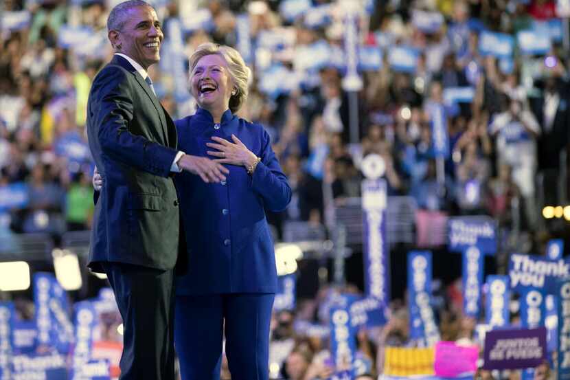 Hillary Clinton, now the party's nominee, and President Barack Obama stand together on stage...